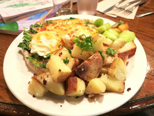 The Naam's miso benny comes with poached eggs over greens, roast potatoes and fruit on West 4th Avenue.