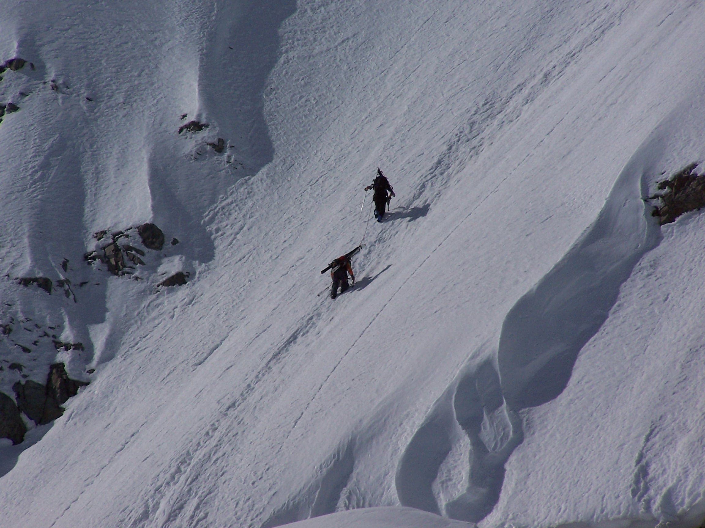 Two ski mountaineers kick steps up the steep snow of Mount Garibaldi's east face above the Garibaldi Neve.