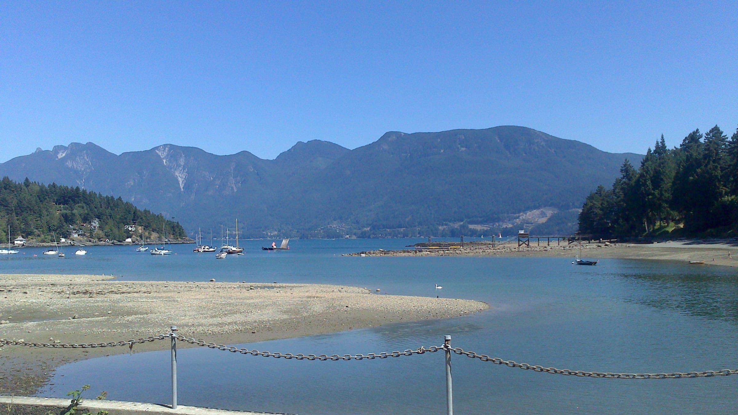 A sandy spit on Bowen Island looks across calm water to the mountains of Howe Sound.