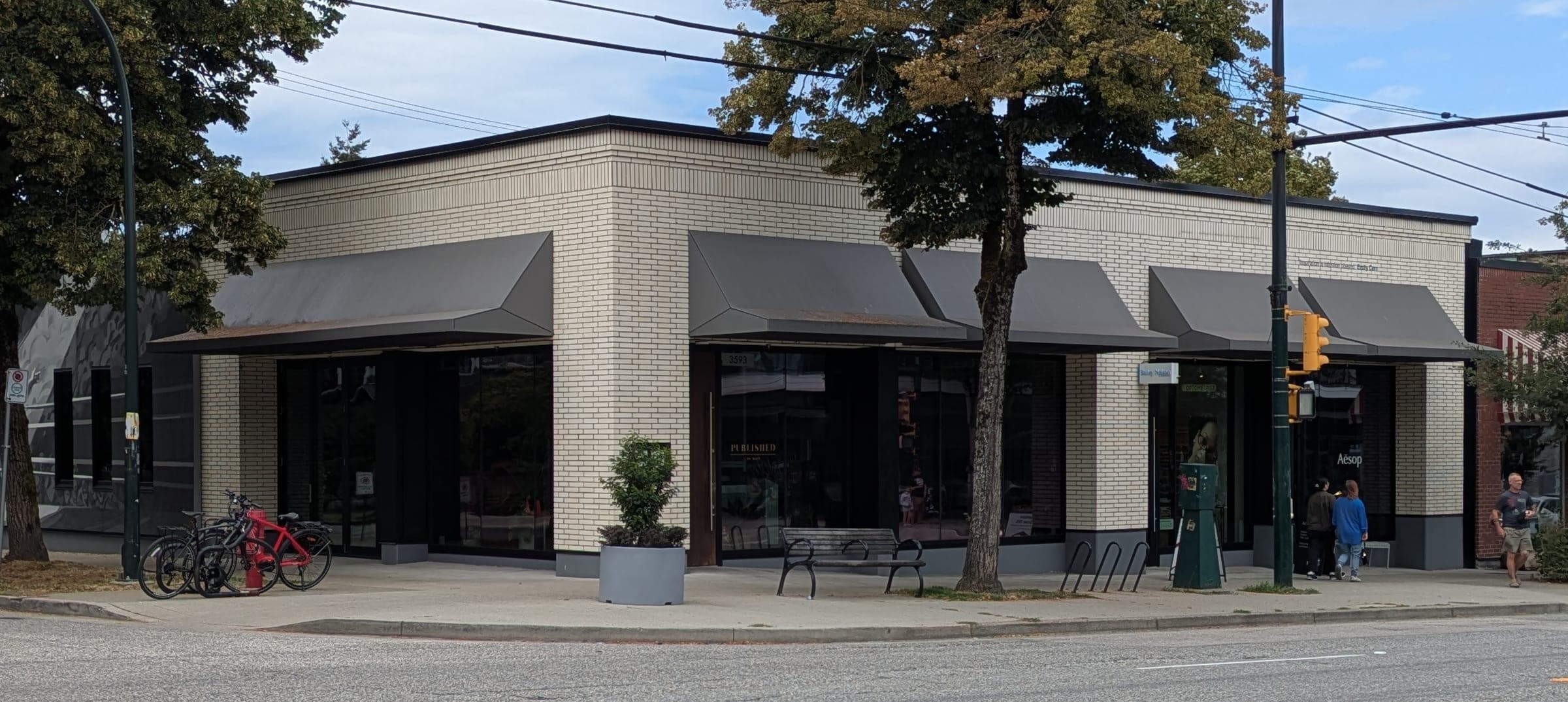 Published on Main's pale brick frontage and grey awnings face Main Street at East 20th Avenue.