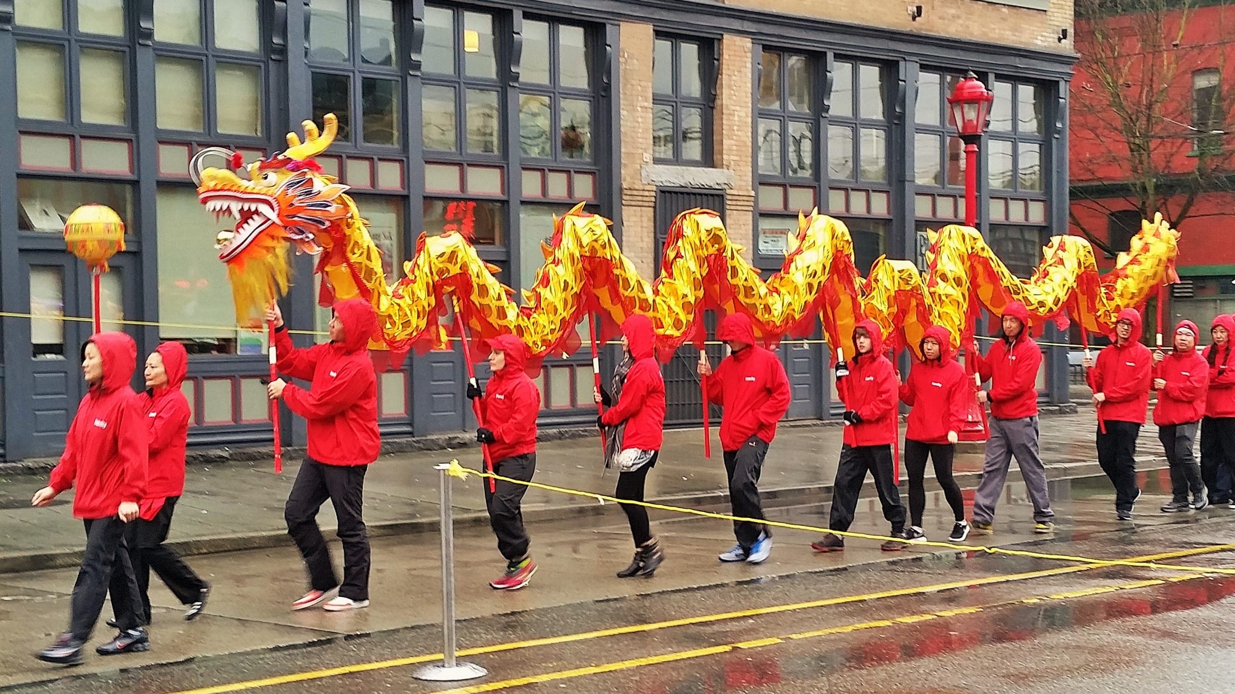 Dancers in red carry a golden dragon down a Chinatown street during Vancouver's Lunar New Year parade.