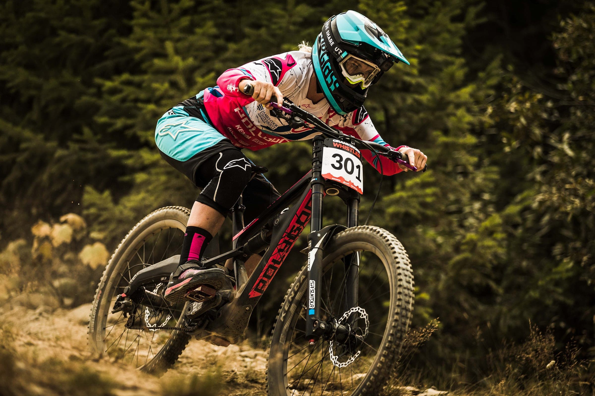 A downhill racer drops through the trees of the Whistler Mountain Bike Park during Crankworx Whistler.