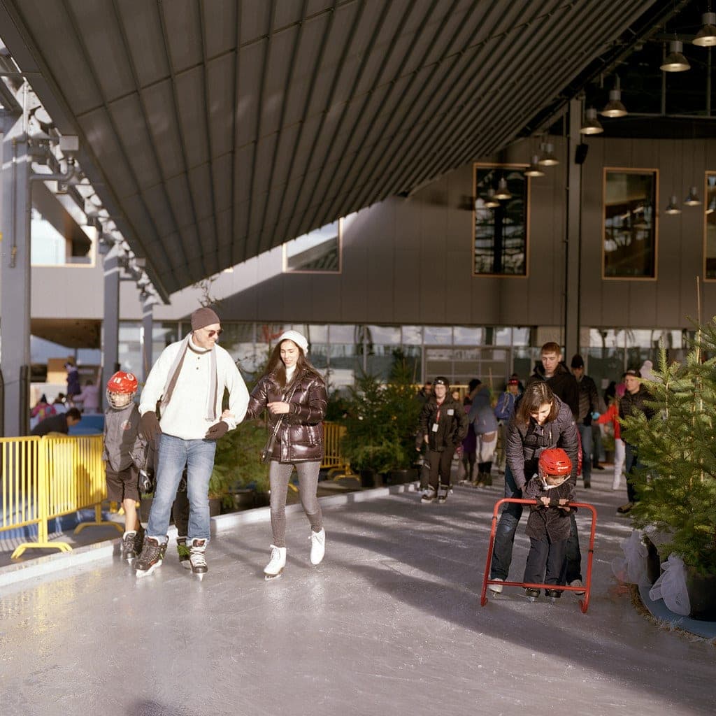 Skaters circle the covered rink of the Shipyards Skate Plaza in Lower Lonsdale on a bright winter day.
