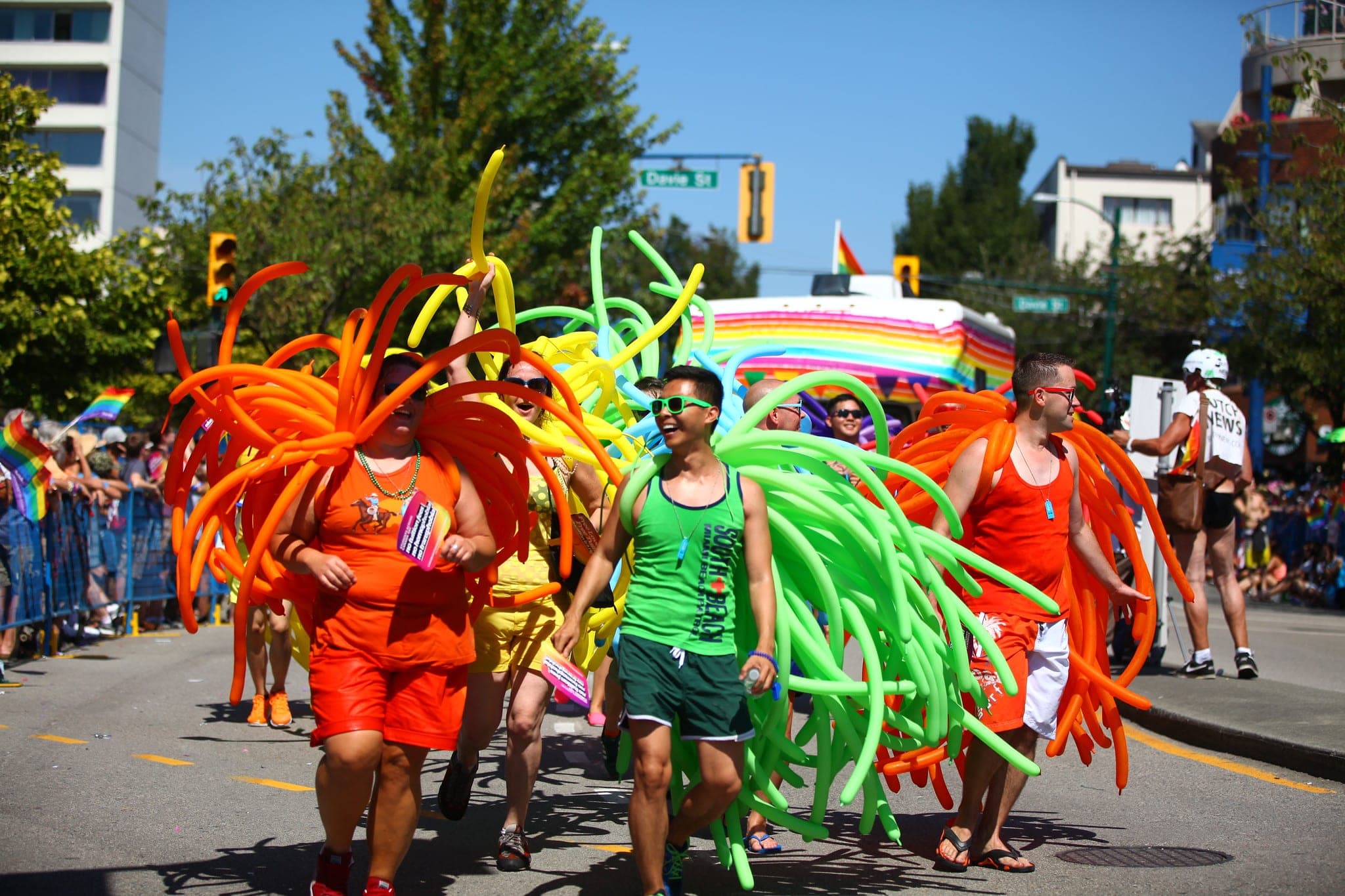 Marchers in rainbow balloon costumes walk past Davie Street in the 2014 Vancouver Pride Parade.