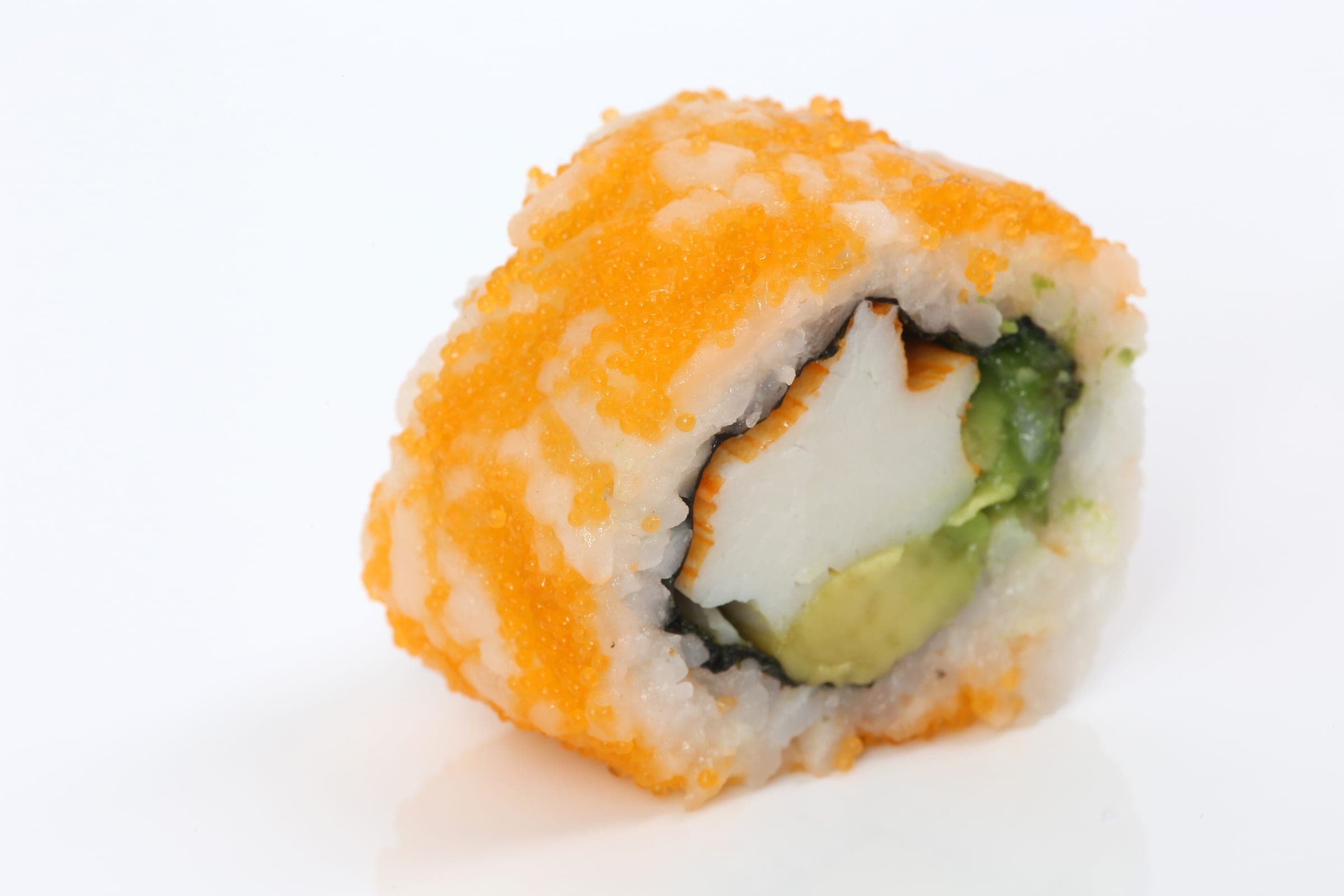 A single California roll piece shows a crab stick, avocado and cucumber inside rice rolled in orange fish roe.