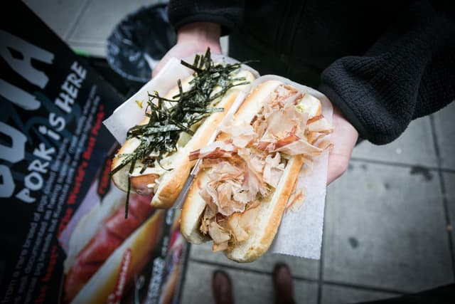 An Okonomi dog under bonito flakes and a Terimayo dog under seaweed from a Japadog cart in downtown Vancouver.