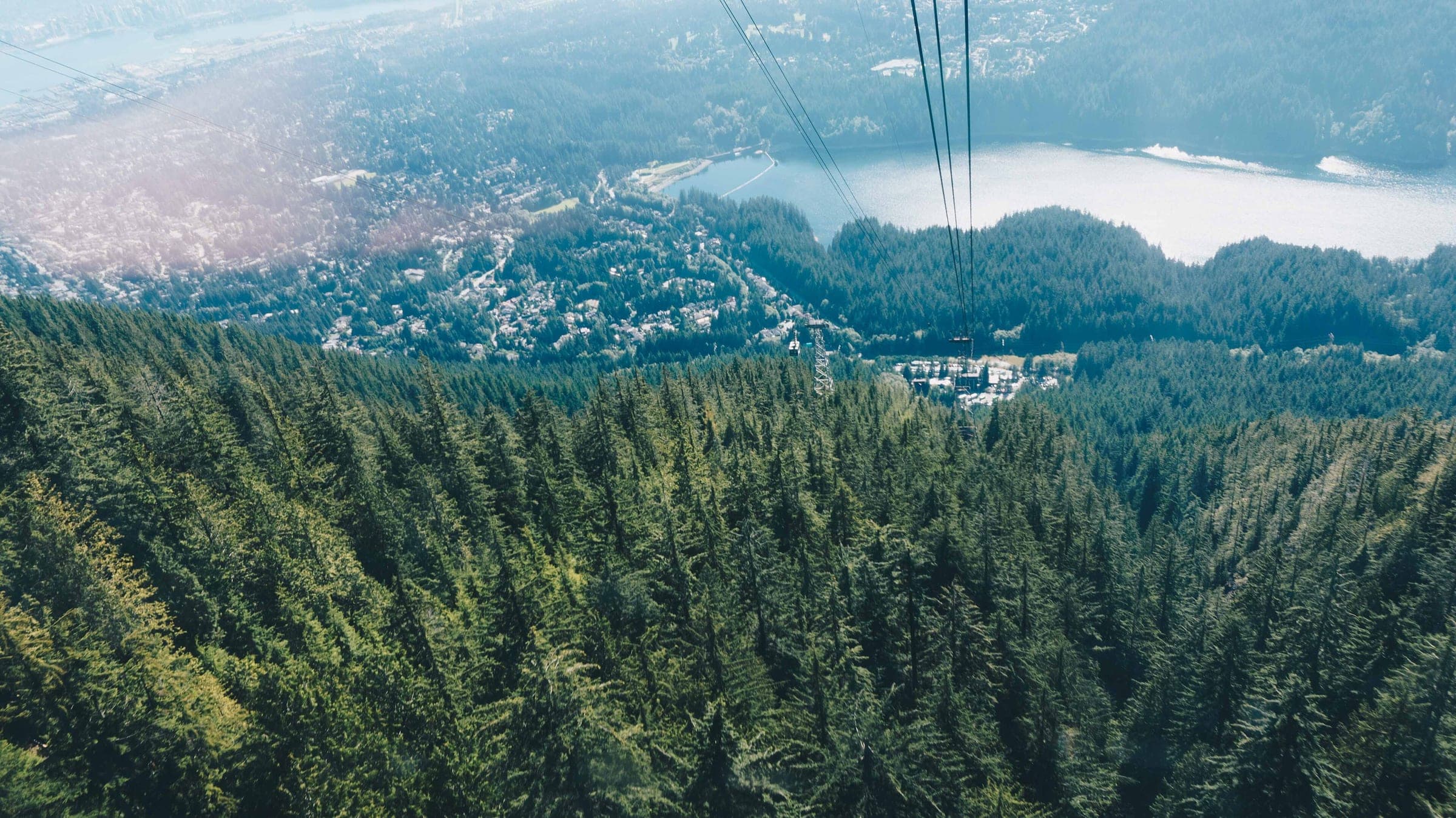 The Grouse Mountain Skyride looks down on the forest the Grouse Grind climbs, with Capilano Lake behind.