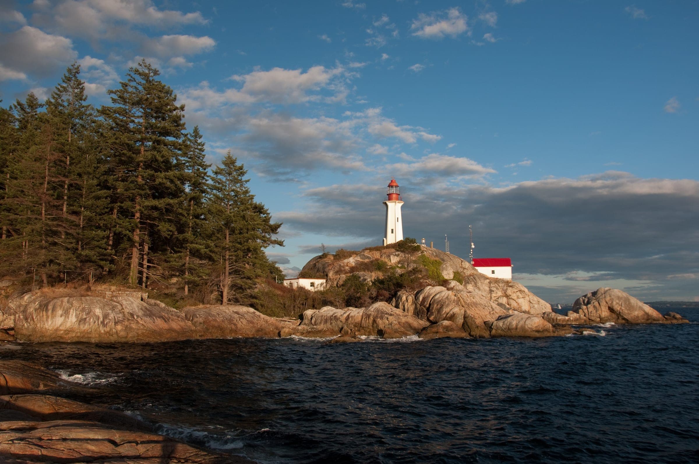 Point Atkinson Lighthouse stands on granite above the waves in Lighthouse Park in late light.