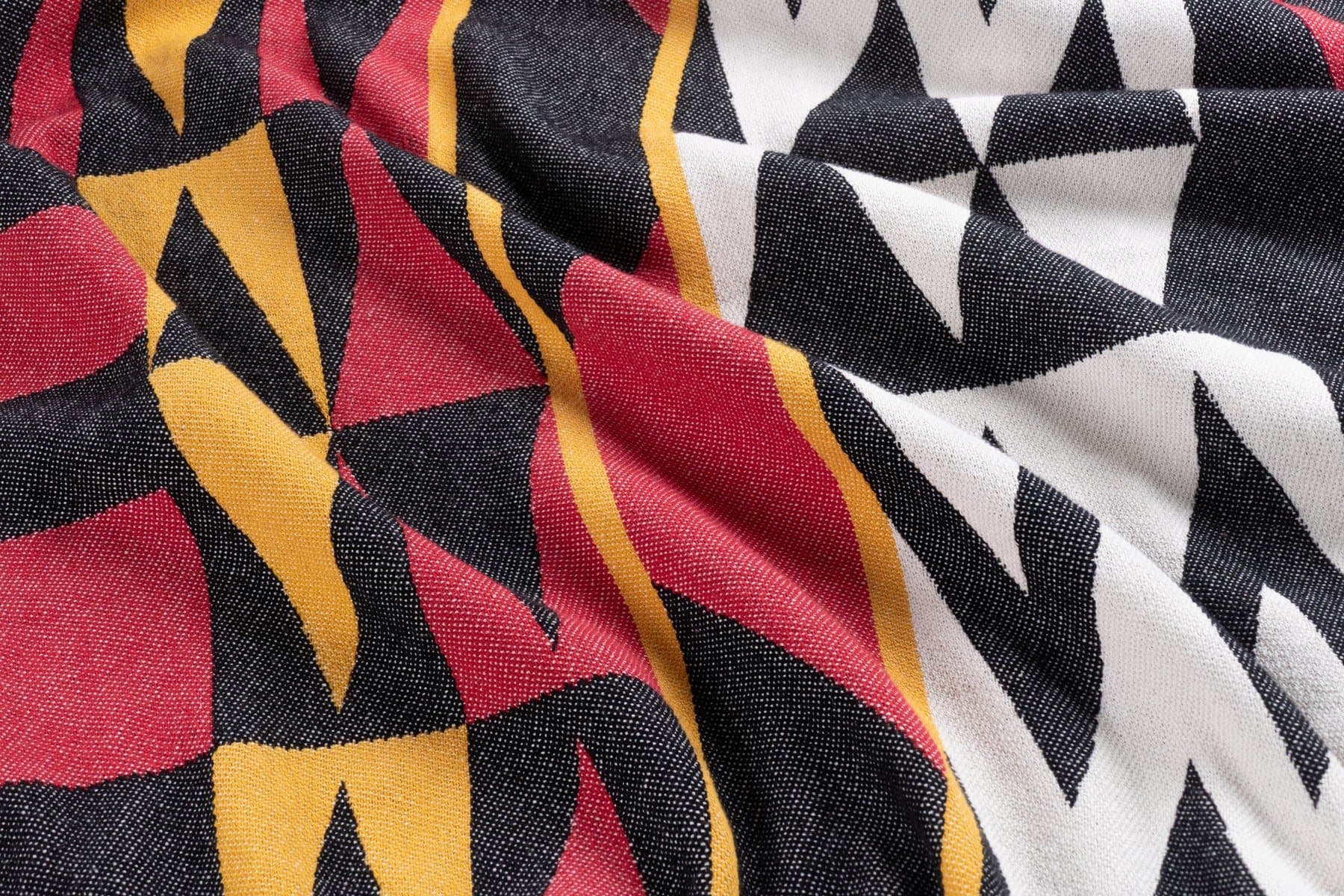 A close view of the Welcome Blanket from Salish Blanket Co., woven in red, gold, black and white.