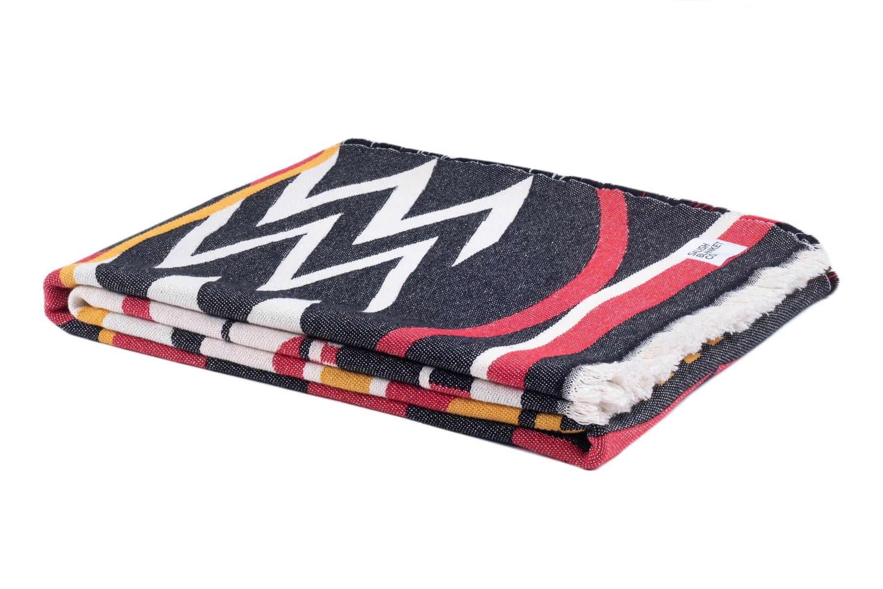 The Welcome Blanket from Salish Blanket Co. folded, with its fringe at the edge.