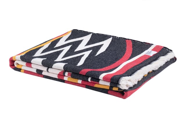 The Welcome Blanket from Salish Blanket Co. folded, with its fringe at the edge.