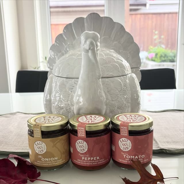 Three jars of East Van Jam savoury spreads, onion, pepper and tomato, in front of a white ceramic turkey.