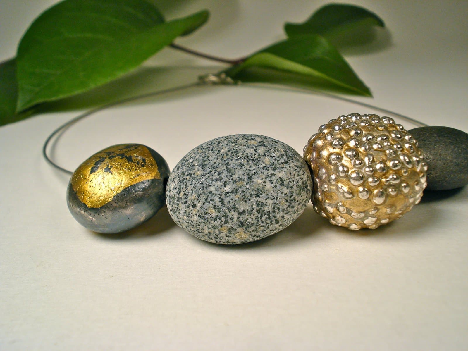 An Effie Baker necklace strung with a gold-leafed pebble, a granite pebble and a textured silver bead.