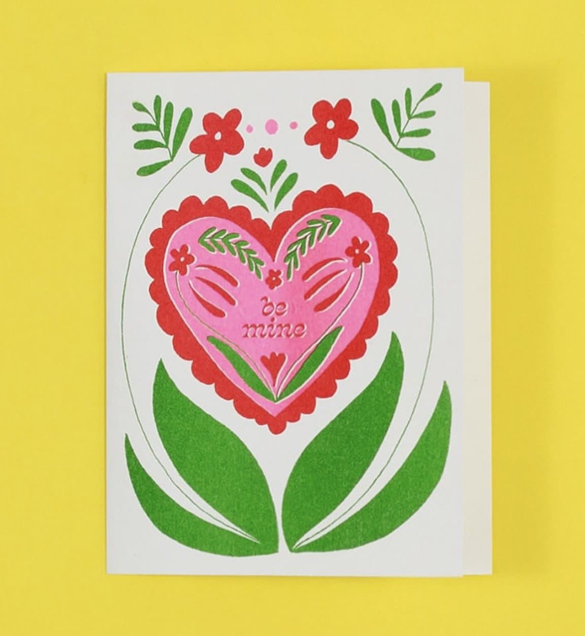 A risograph greeting card from Steph Ford Studio printed with a red folk-style heart and green tulips.