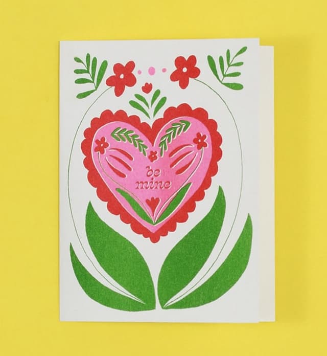 A risograph greeting card from Steph Ford Studio printed with a red folk-style heart and green tulips.