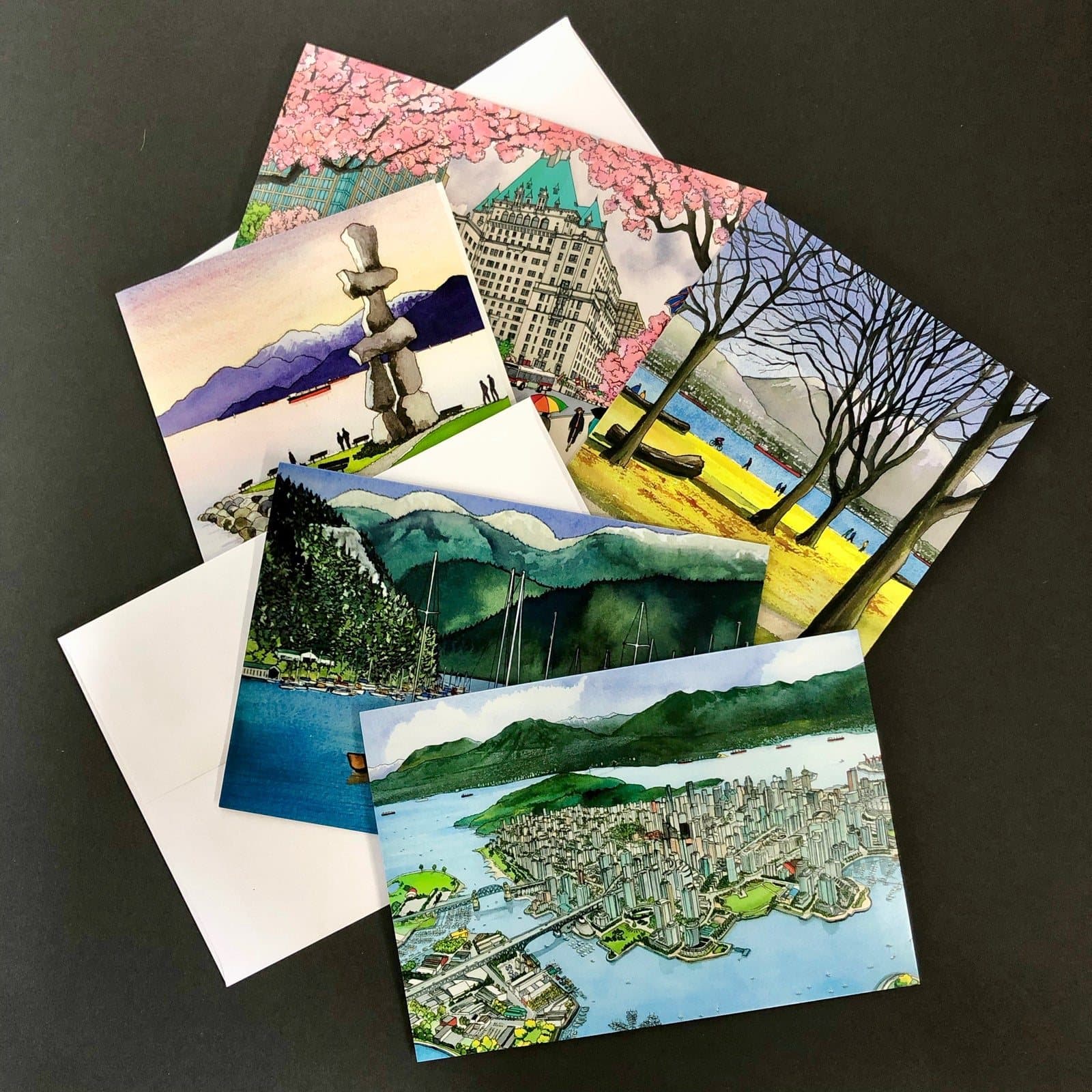 Hilary Morris greeting cards printed with her watercolours of Vancouver scenes, fanned out on a dark table.