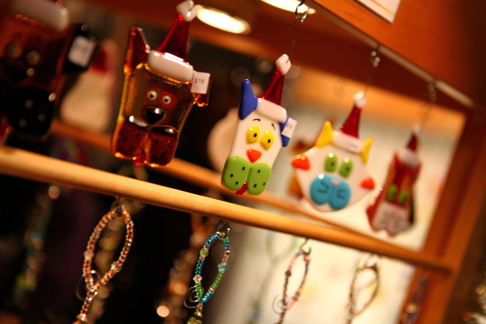 Glass ornaments shaped like owls and houses hang on a stall at the Circle Craft Christmas Market in Vancouver.