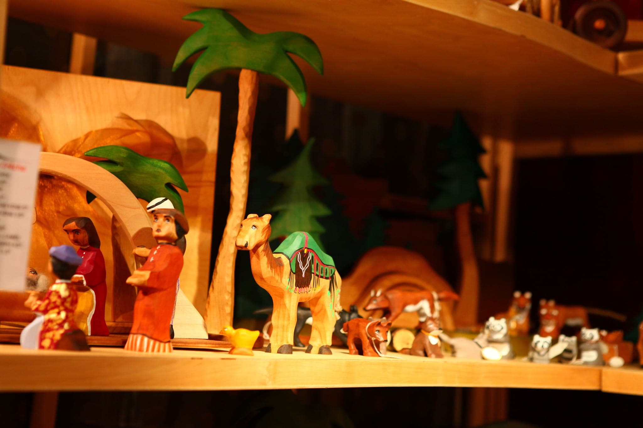 Hand-carved wooden animals and palm trees fill a maker's shelf at the Circle Craft Christmas Market in Vancouver.