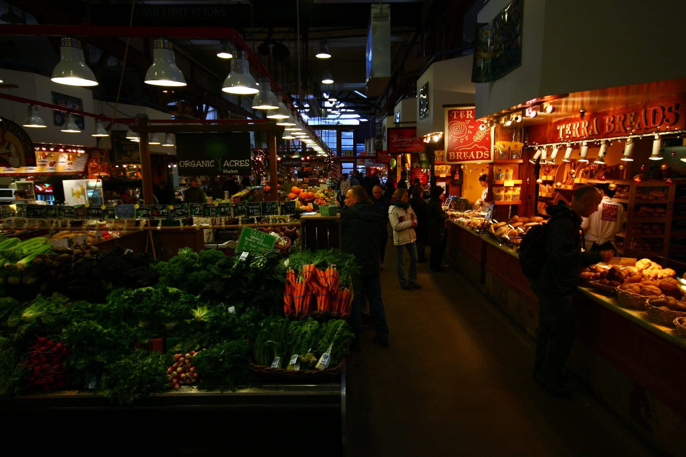 Produce stalls light an aisle inside the Granville Island Public Market in December.