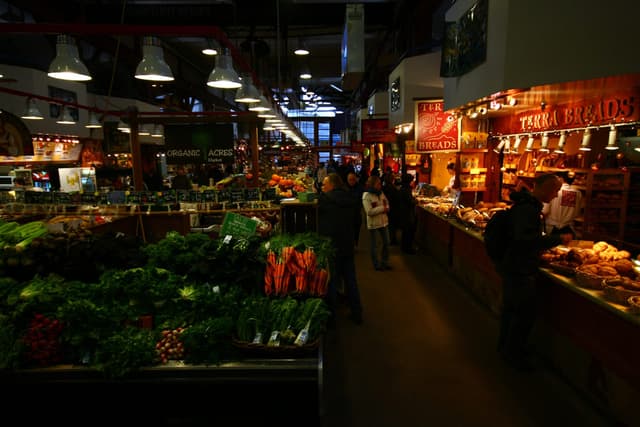 Produce stalls light an aisle inside the Granville Island Public Market in December.