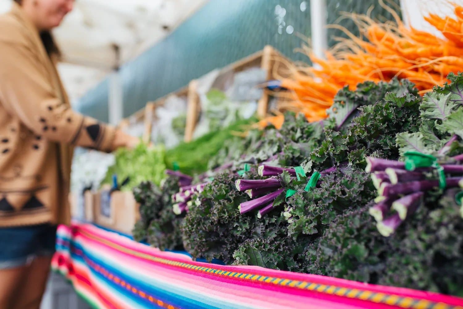 Kale and carrots on a stall under a canopy at the Squamish Farmers Market.