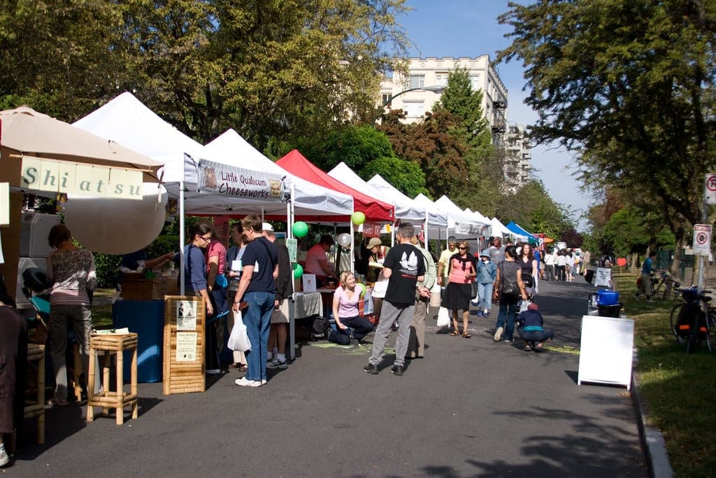Shoppers walk between rows of tents at the West End Farmers Market on Comox Street