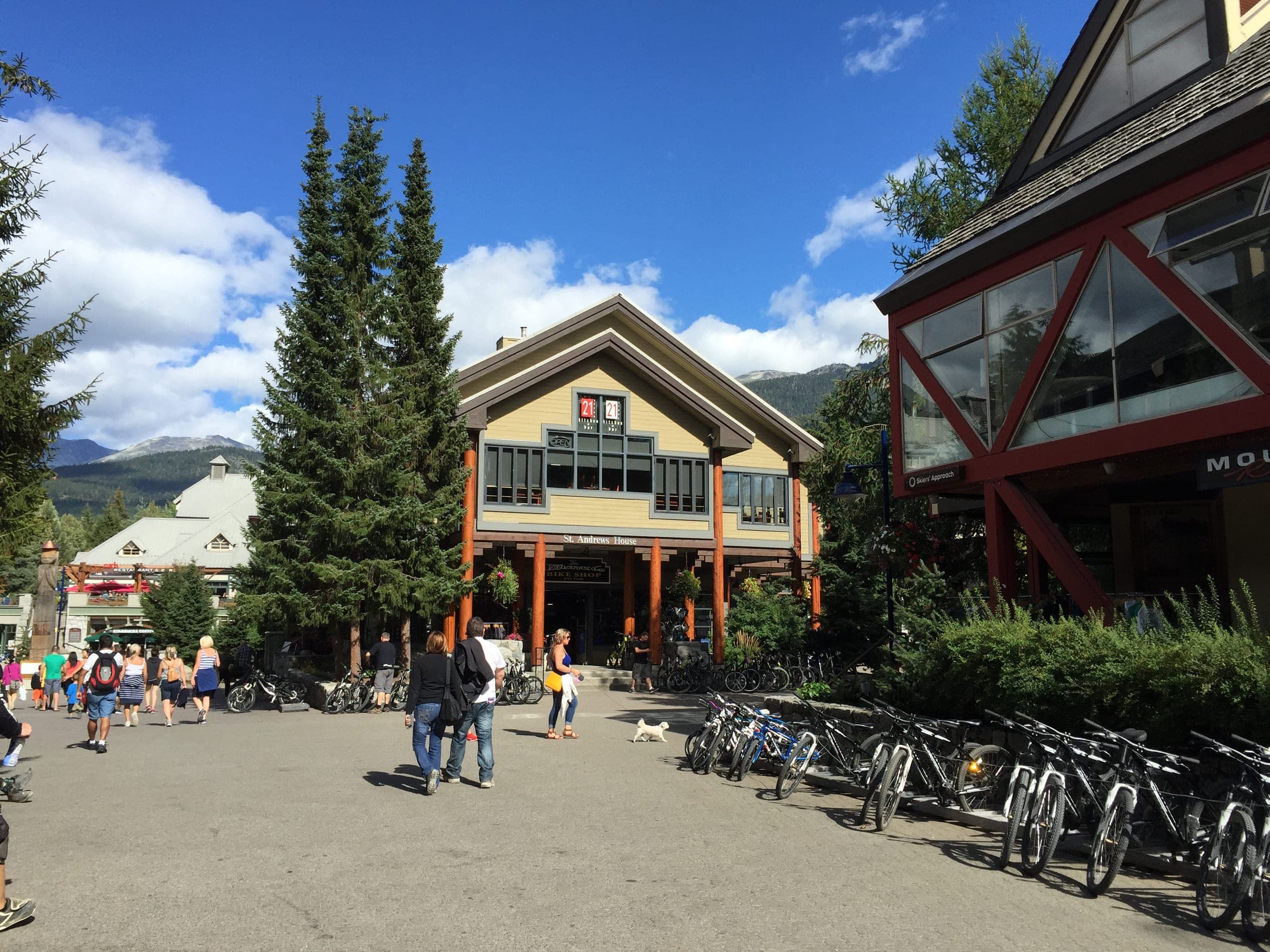 Bikes line the racks beside the Village Green in Whistler Village on a sunny day.