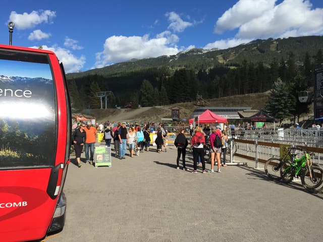 Riders and visitors gather at the Whistler Gondola base in Whistler Village on a summer day.