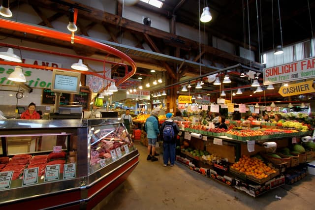 Shoppers walk the produce and meat stalls inside Granville Island Public Market in Vancouver.