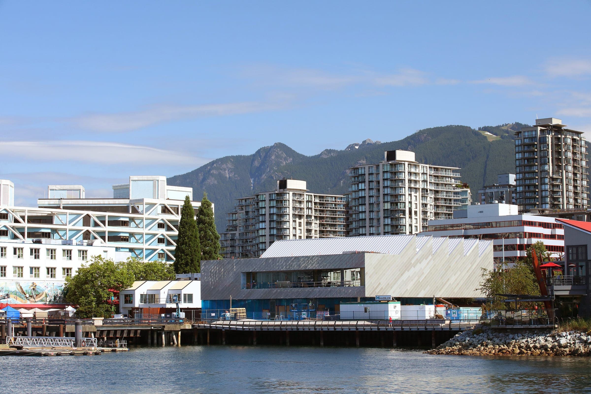 The Polygon Gallery sits on the Shipyards waterfront below Lower Lonsdale's towers and the North Shore mountains.
