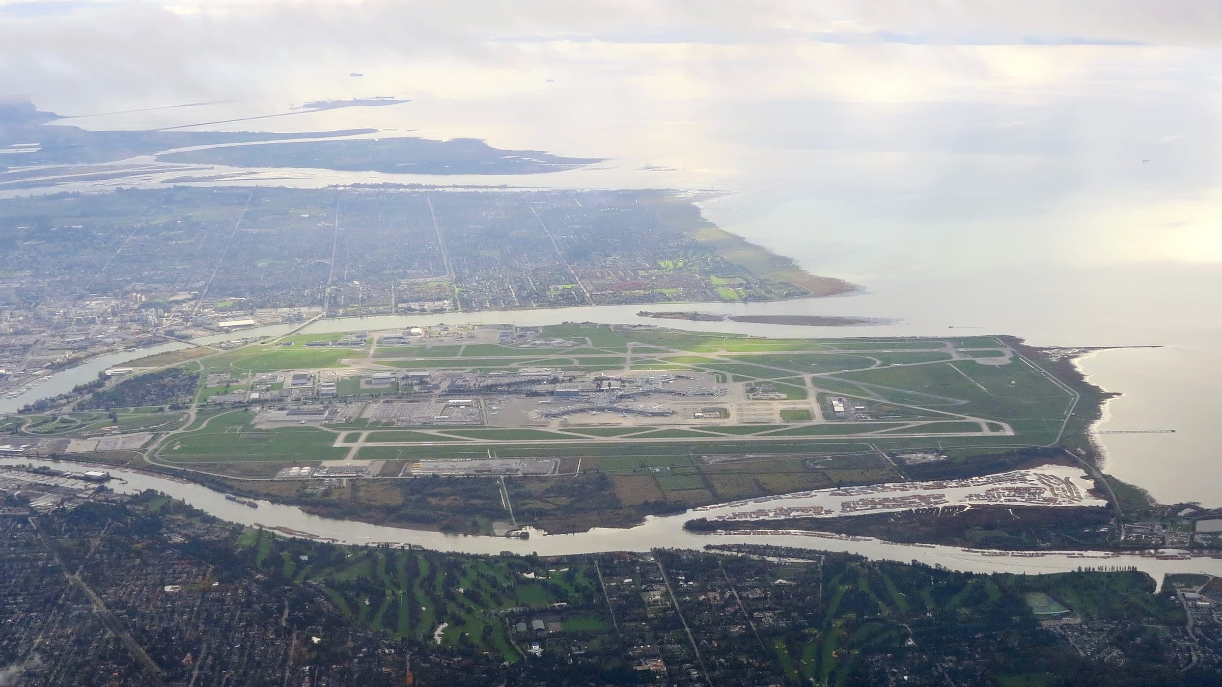 Vancouver International Airport fills Sea Island between the arms of the Fraser River in an aerial view of Richmond.