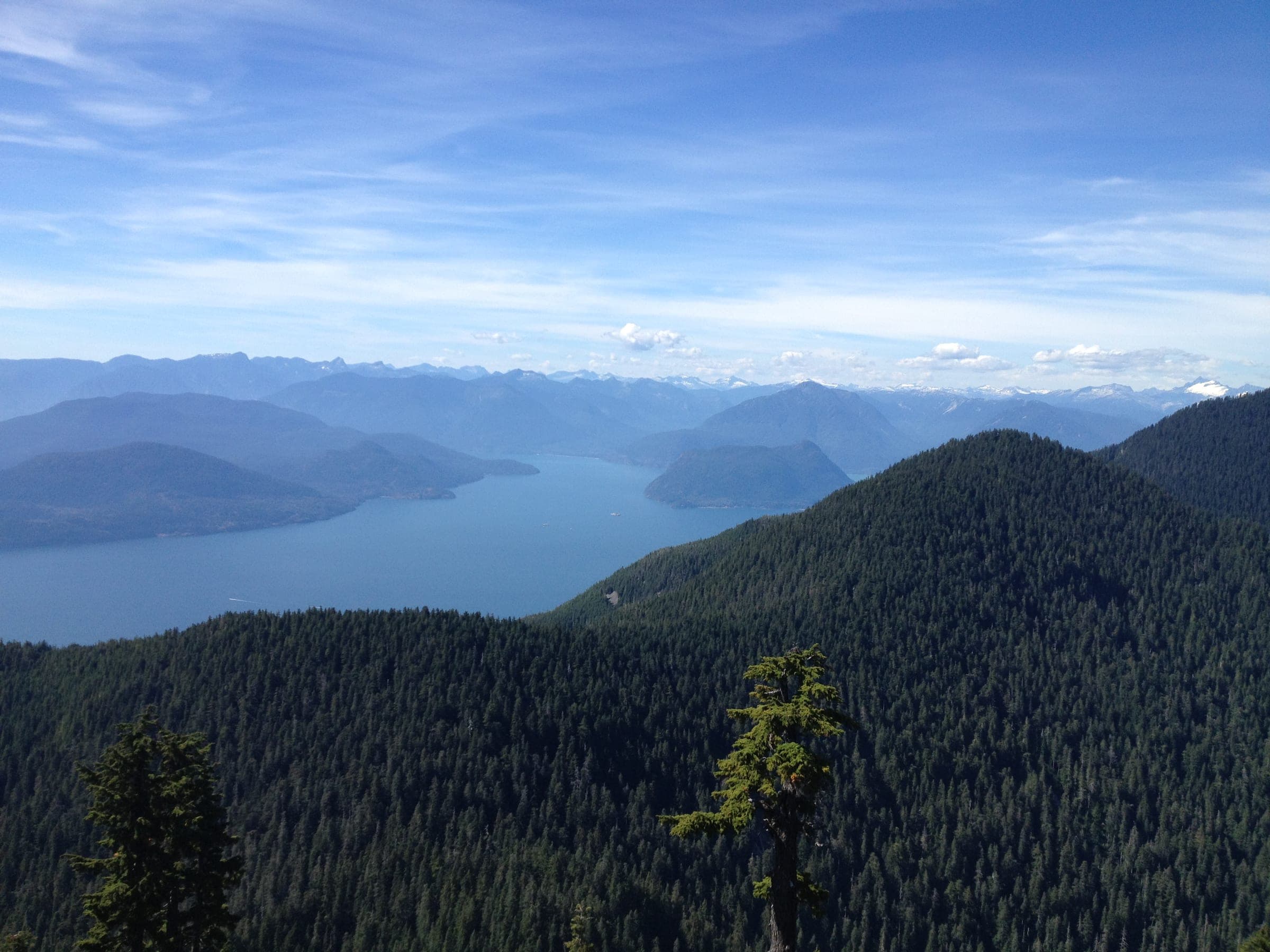 Forested Cypress slopes fall away to Howe Sound and its islands under a wide summer sky.