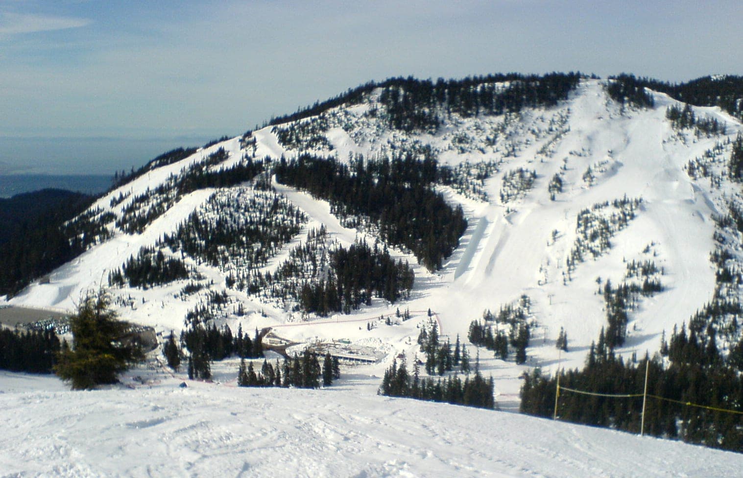 Ski runs and gladed slopes cover a snowy Cypress Mountain peak above the base lodge.