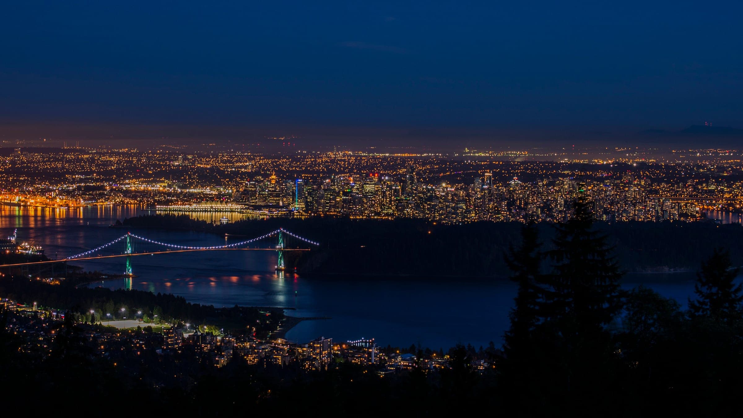 Vancouver and the Lions Gate Bridge glow at night below the Cypress Bowl Road lookout.