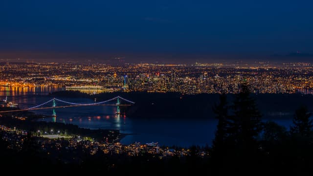 Vancouver and the Lions Gate Bridge glow at night below the Cypress Bowl Road lookout.