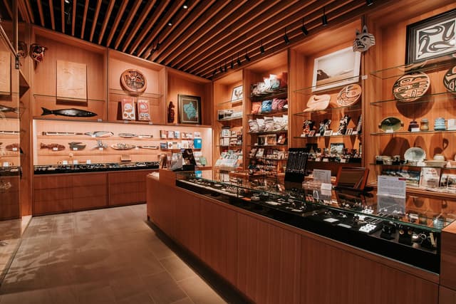 The Audain Art Museum Shop counter with books, crafts and gifts on the shelves behind it.