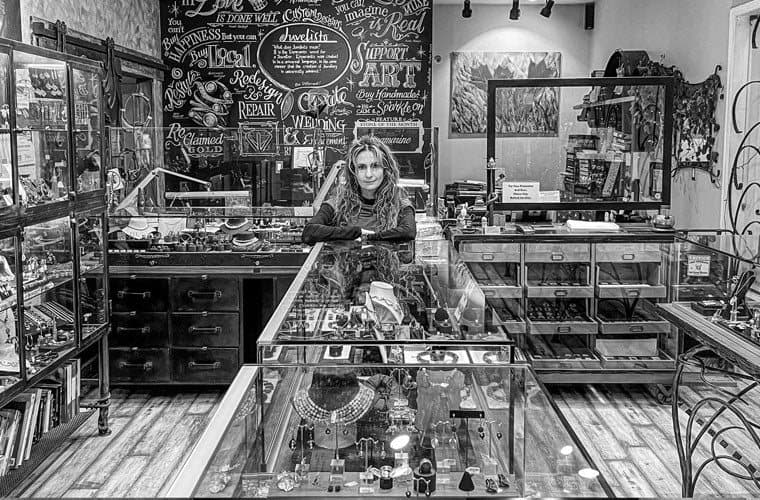 Inside the Juvelisto jewellery shop with glass display counters and a chalkboard wall behind.