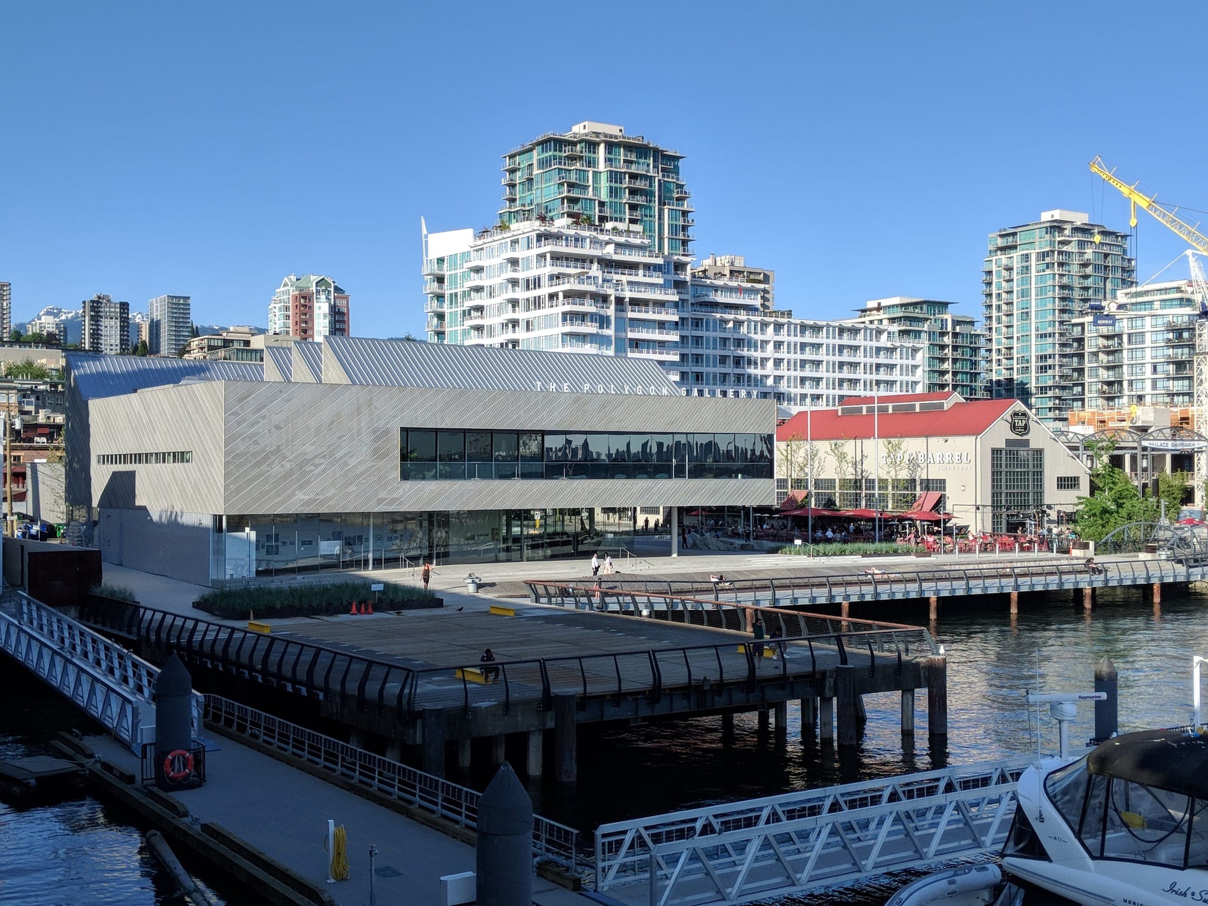 The Polygon Gallery on the North Vancouver waterfront seen from the Shipyards with moored boats in front.
