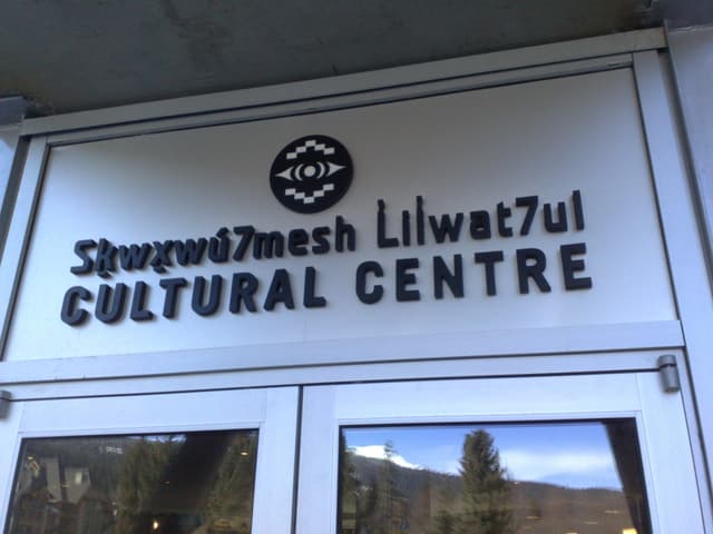 Entrance sign of the Squamish Lil'wat Cultural Centre in Whistler with its two-language name.