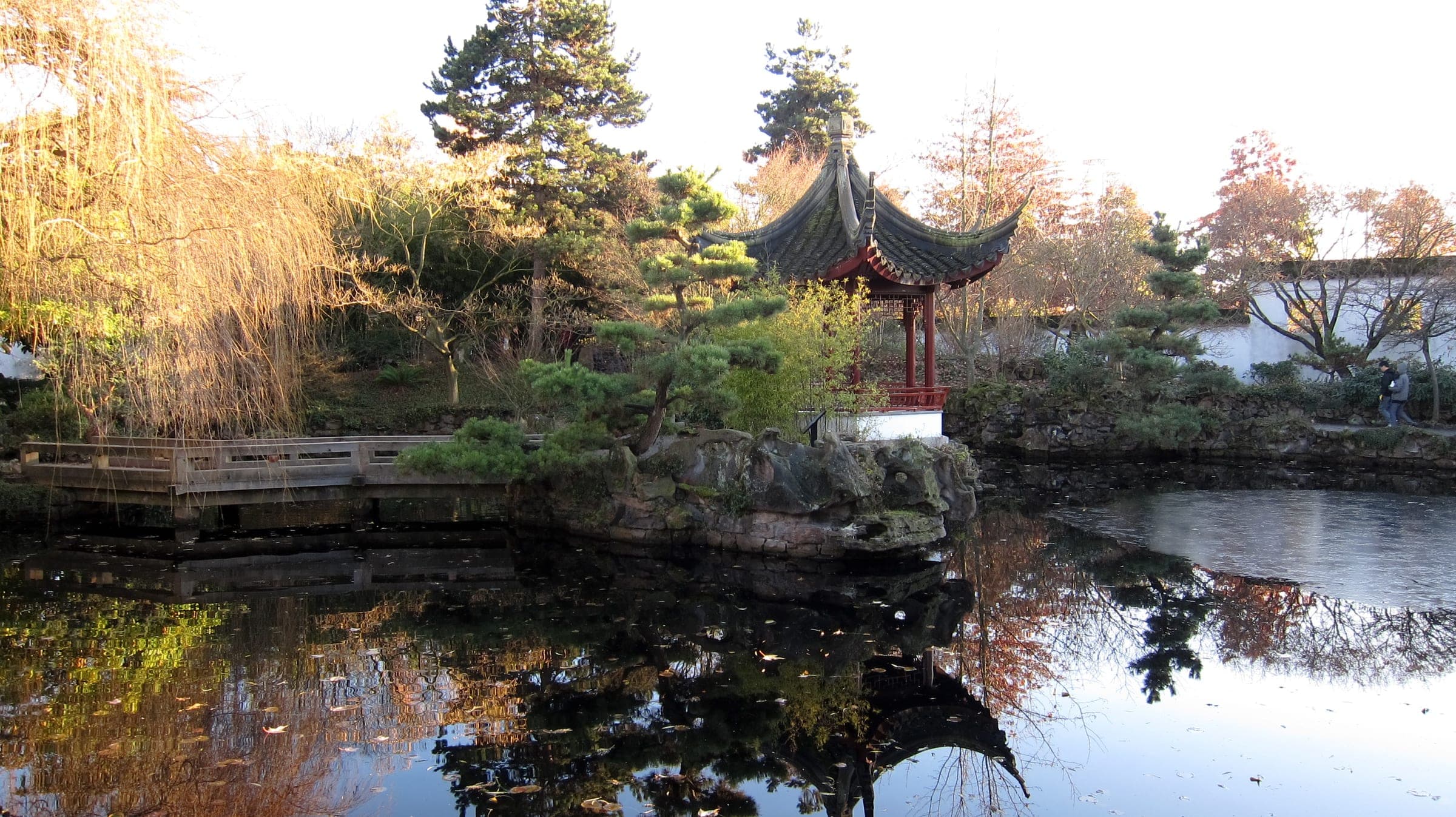A red pavilion and pines stand over the still jade pond at the Dr. Sun Yat-Sen garden on a December afternoon.