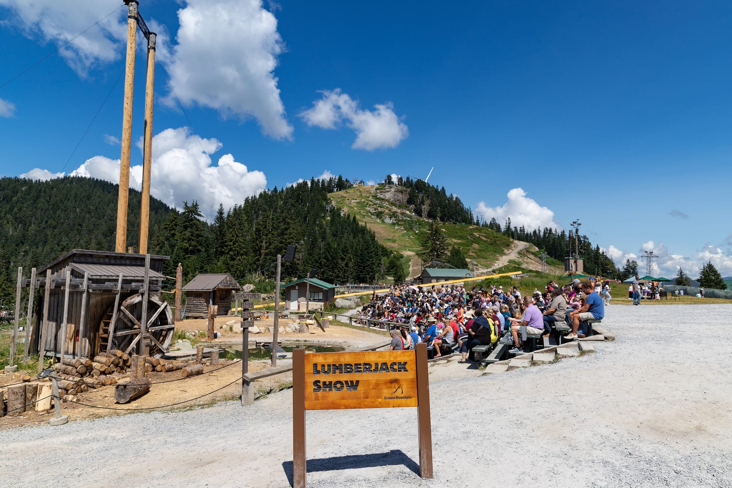 A crowd fills the benches for the Lumberjack Show on the summit plateau of Grouse Mountain in summer.