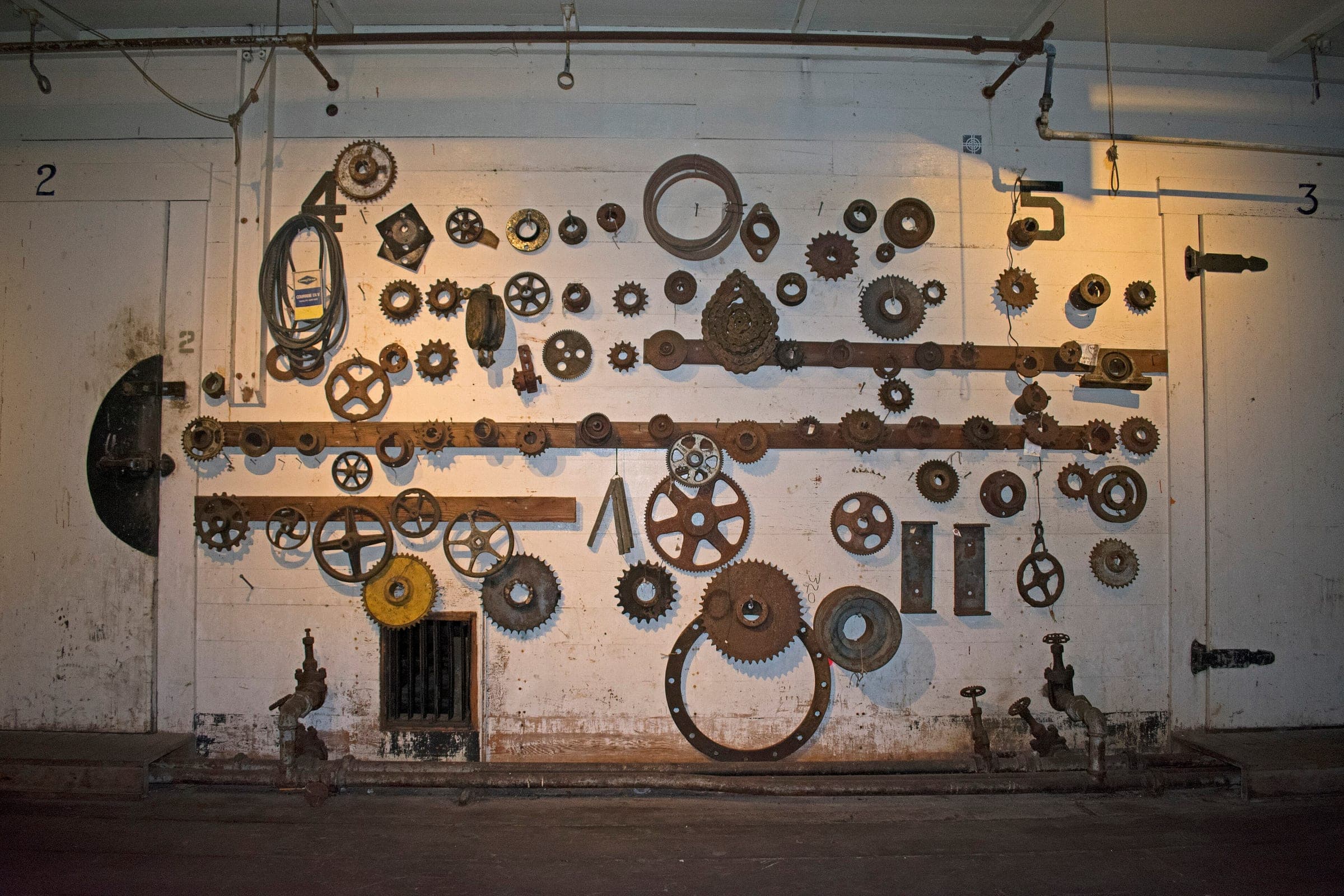 Old gears and sprockets from the canning lines hang on a wall inside the Gulf of Georgia Cannery.