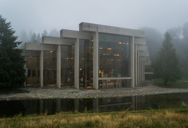 Fog hangs over the Museum of Anthropology at UBC as its concrete frame doubles in the pond.