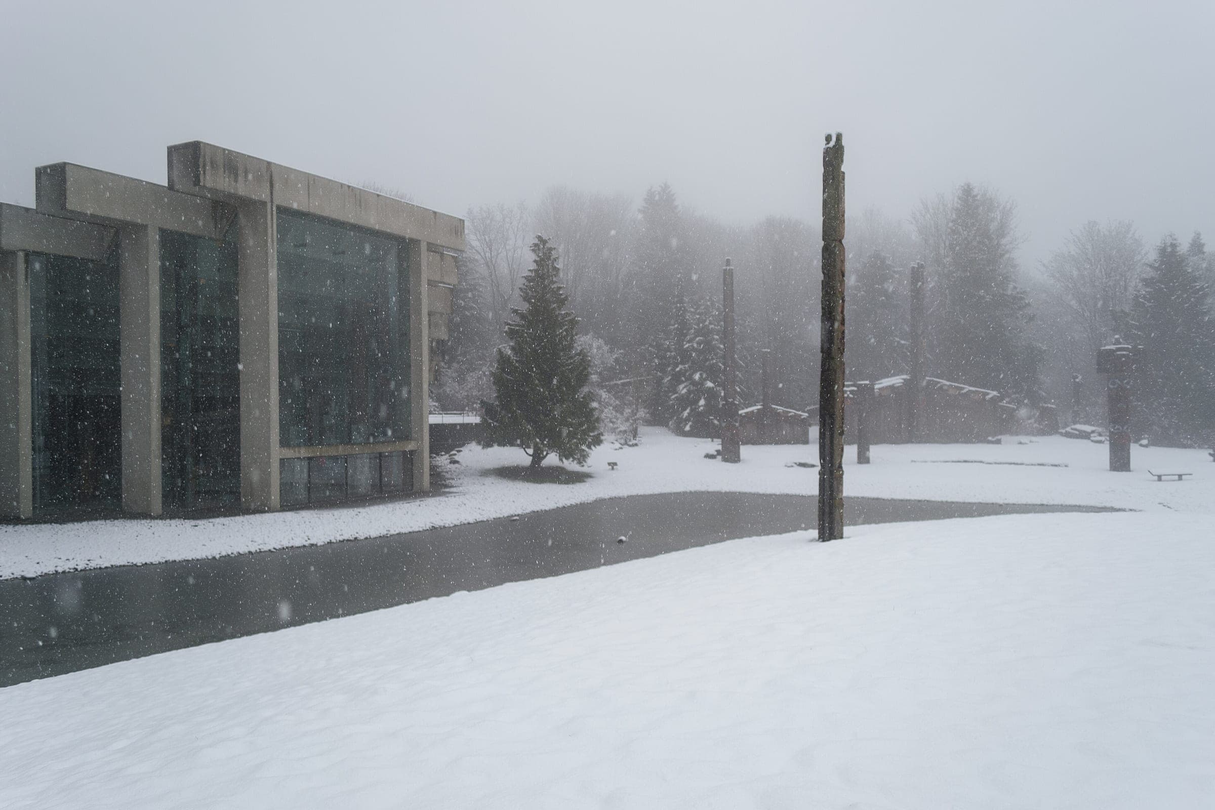 Snow covers the lawn and the pond in front of the Museum of Anthropology's Great Hall at UBC.