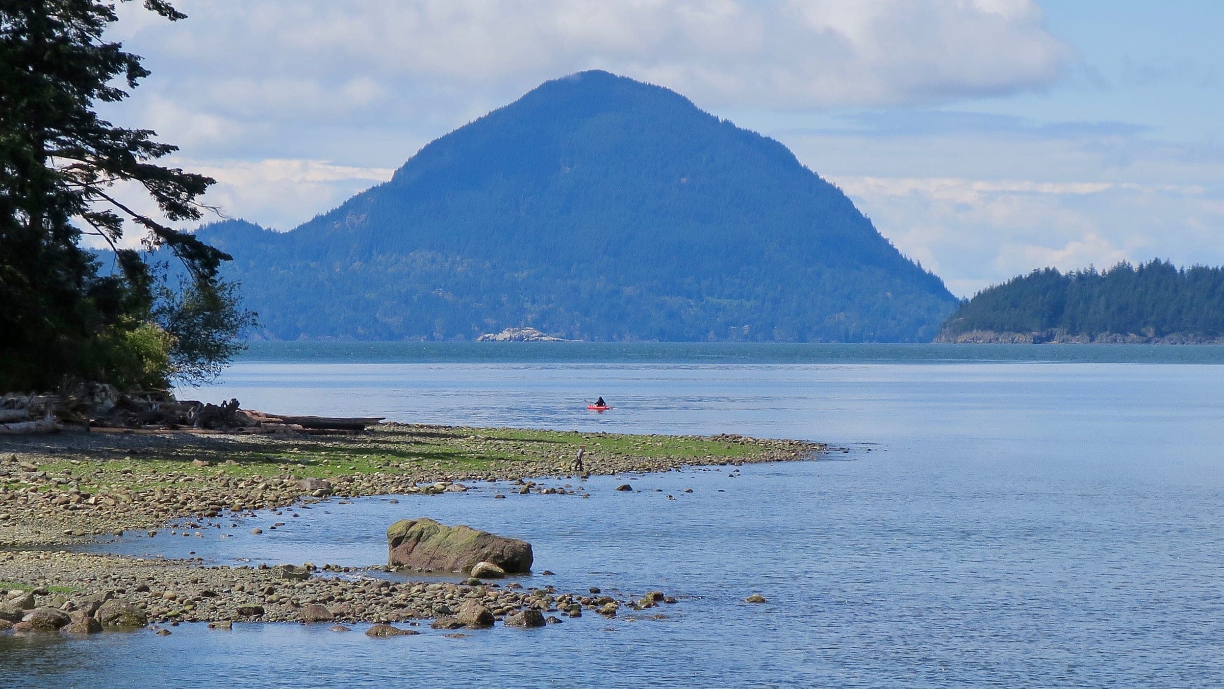 A pebble spit at low tide reaches toward Anvil Island across Howe Sound from Porteau Cove.