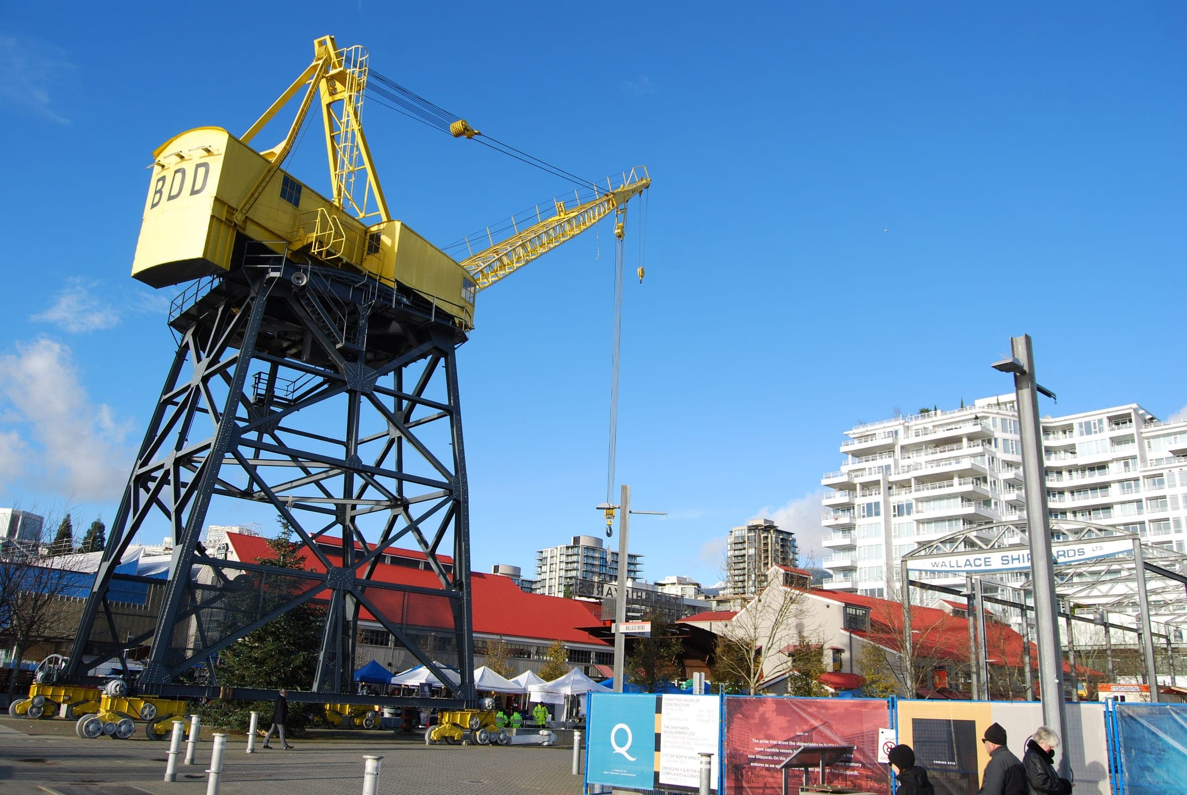 The yellow Burrard Dry Dock crane stands over the Shipyards plaza in North Vancouver on a winter day.