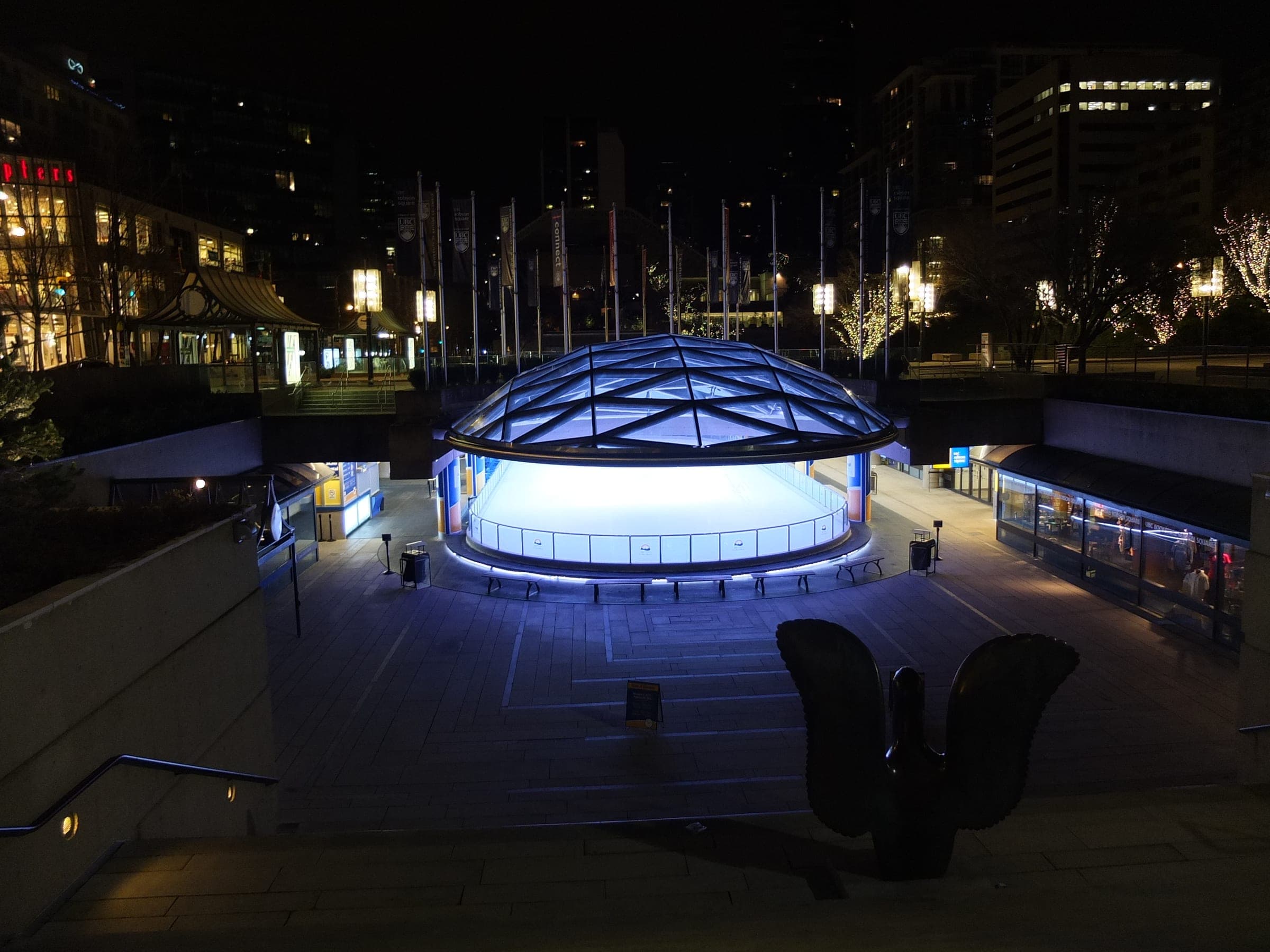 The glass dome over the Robson Square ice rink glows at night across Robson Street from the Vancouver Art Gallery.