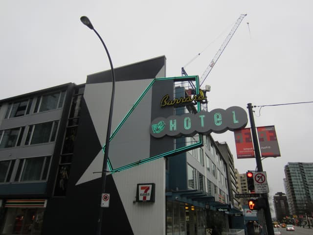 The Burrard hotel on Burrard Street with its teal neon sign above the street.