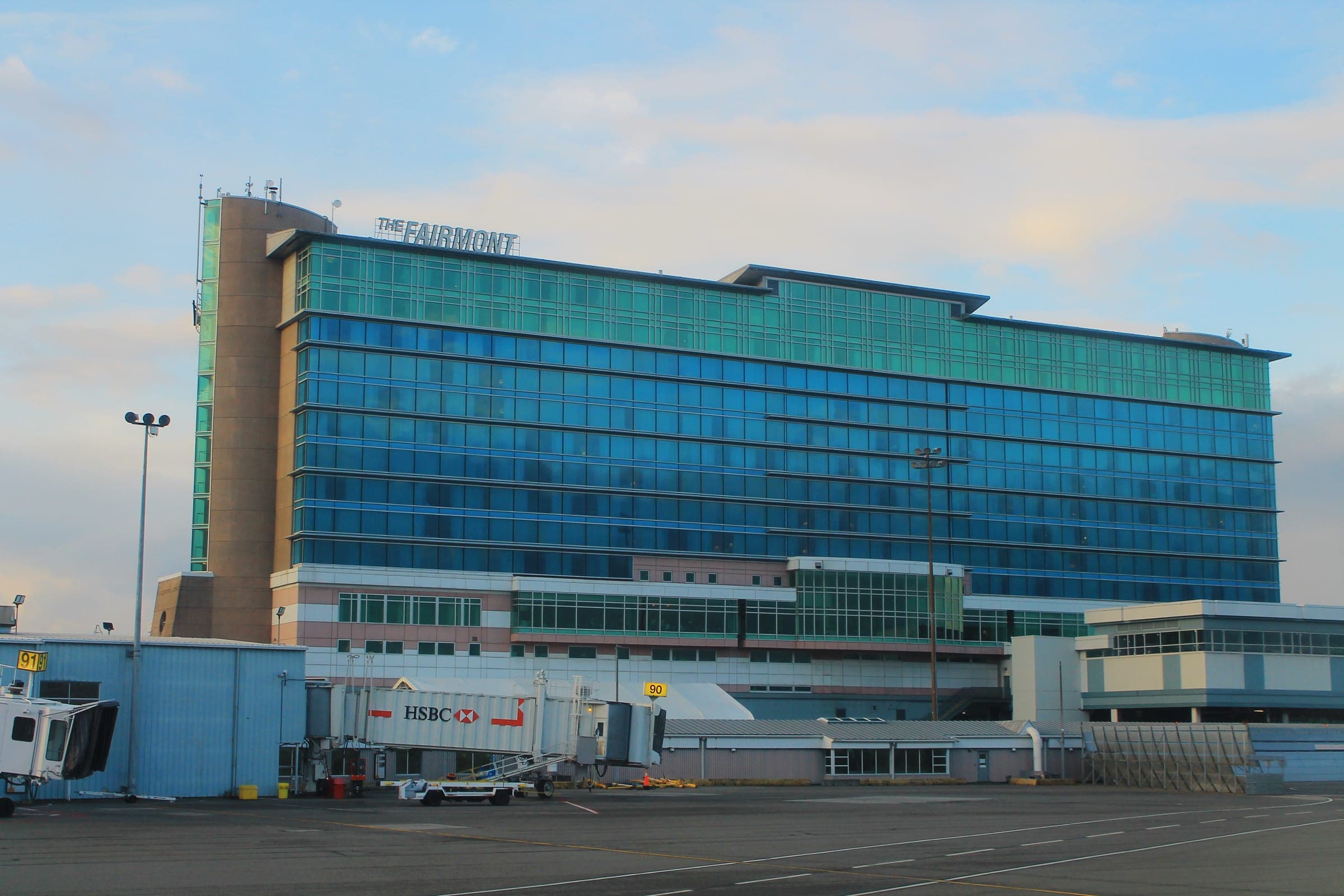 The blue glass tower of the Fairmont Vancouver Airport rises above the terminal apron at YVR.