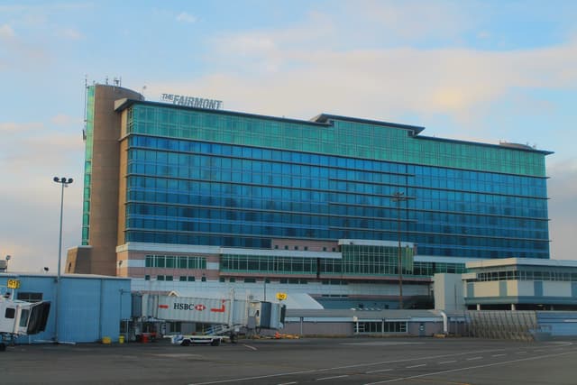 The blue glass tower of the Fairmont Vancouver Airport rises above the terminal apron at YVR.
